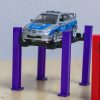 Elevator auto miniatural la scară 1:64, compatibil cu machete Hot Wheels și Matchbox, plasat într-un decor de garaj pentru diorame.