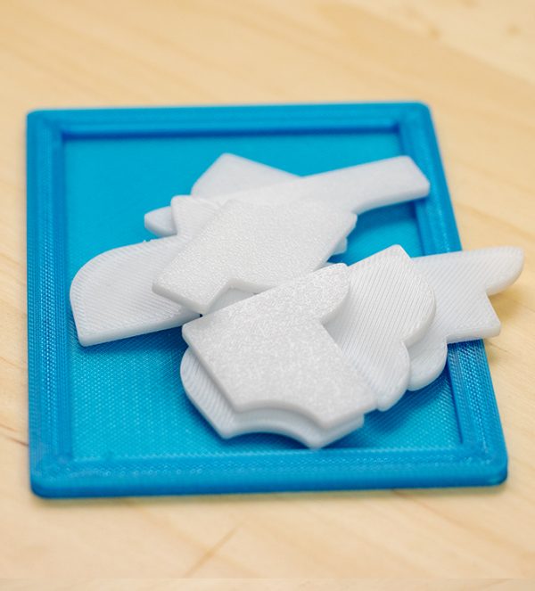 Puzzle 3D cu 10 piese albe, așezate pe o ramă albastră, realizat prin printare 3D, nivel dificultate 8/10.