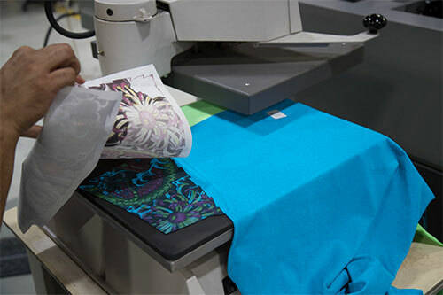 prezentare cum se elimina foaia de sublimare de pe imprimeul unui tricou care este asezat pe presa termica